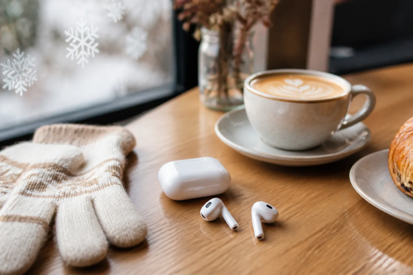 Image spot: earbuds and their case beside a latte